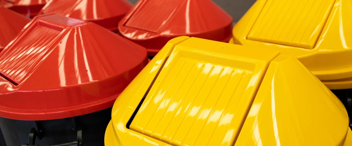 Red and yellow dome shaped recycling containers used for waste collection