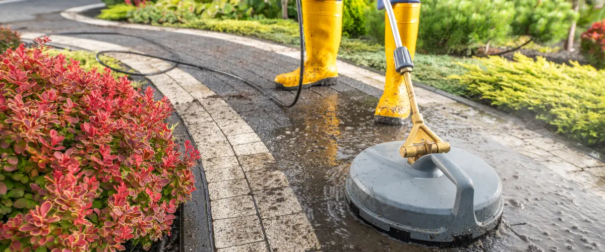 High pressure washing cleaning concrete patio slabs outdoors