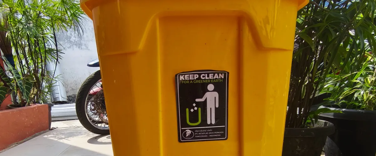 Yellow trash bin with keep clean sign promoting proper waste disposal Yellow trash bin with keep clean sign promoting proper waste disposal