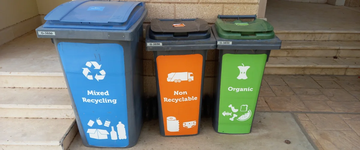 Color-coded recycling bins for trash, recycling, and compost disposal.