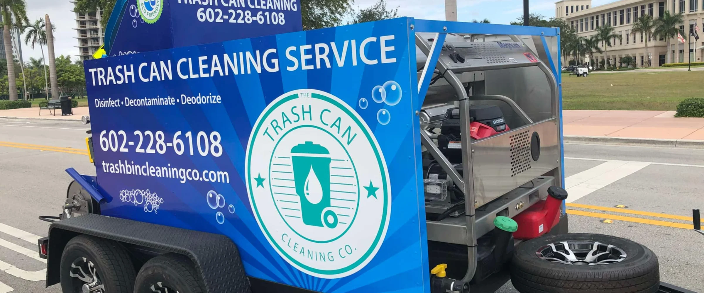 A blue 'Trash Can Cleaning Service' trailer with branding, phone number, and website, parked on a street. A blue 'Trash Can Cleaning Service' trailer with branding, phone number, and website, parked on a street.