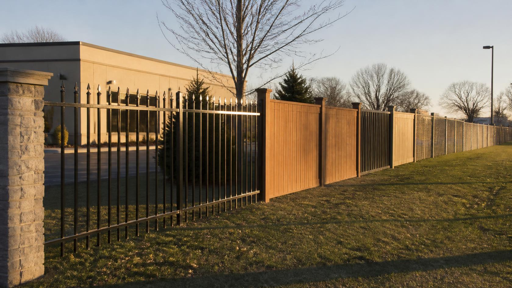 Commercial fence project in Delavan, WI with property owners reviewing materials, layout, gates, labor, and other factors affecting late-season costs.