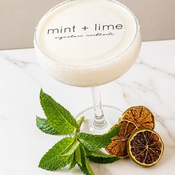 Coupe cocktail with a printed logo drink topper on the foam