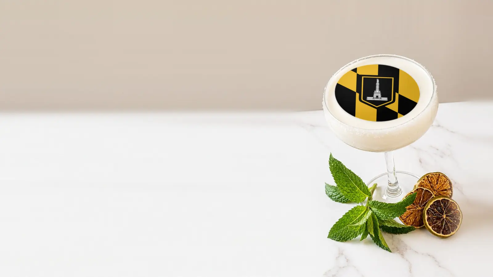 Coupe cocktail topped with a round edible frosting sheet topper printed with the Baltimore city flag