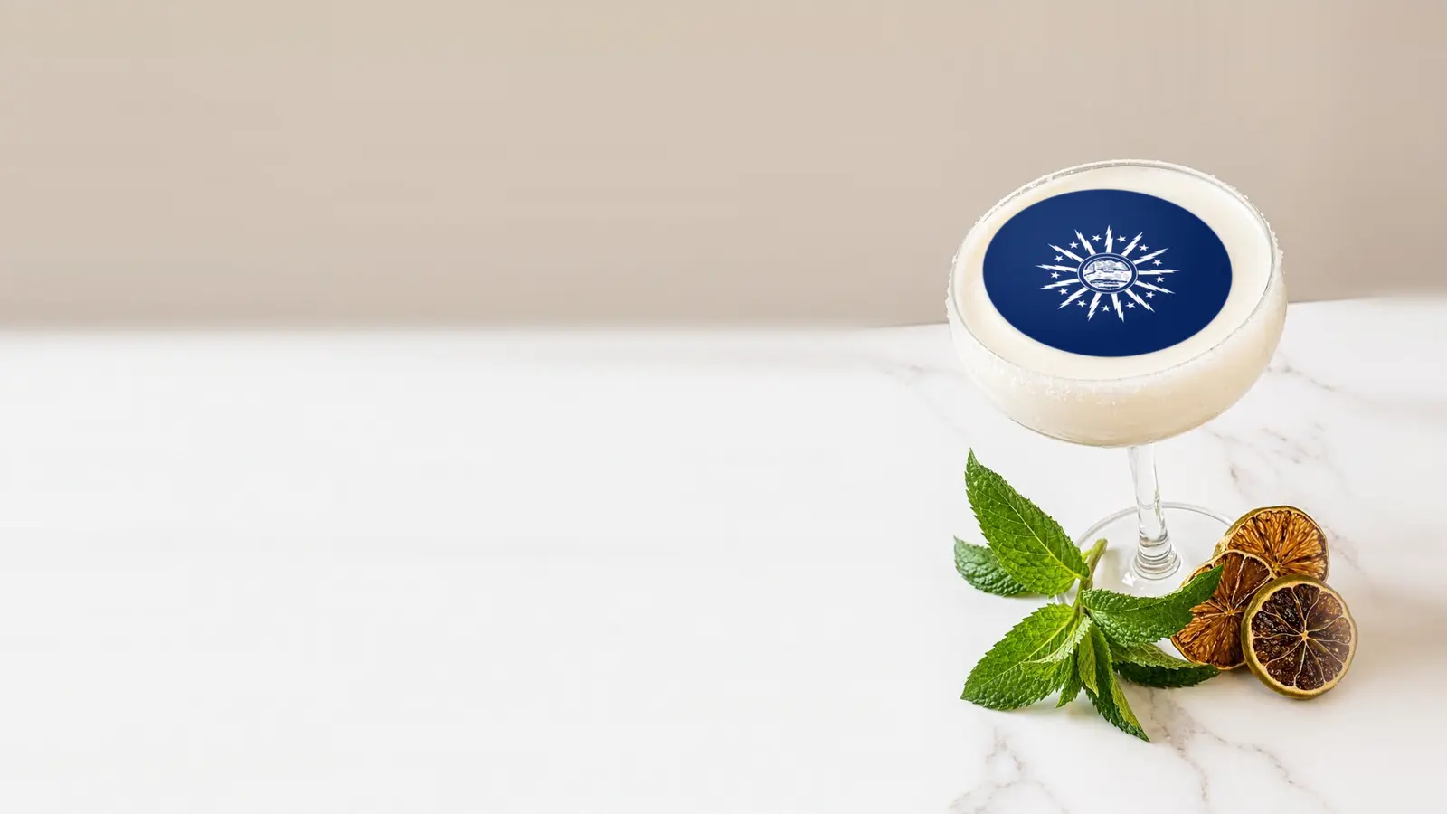 Coupe cocktail topped with a round edible frosting sheet topper printed with the Buffalo city flag