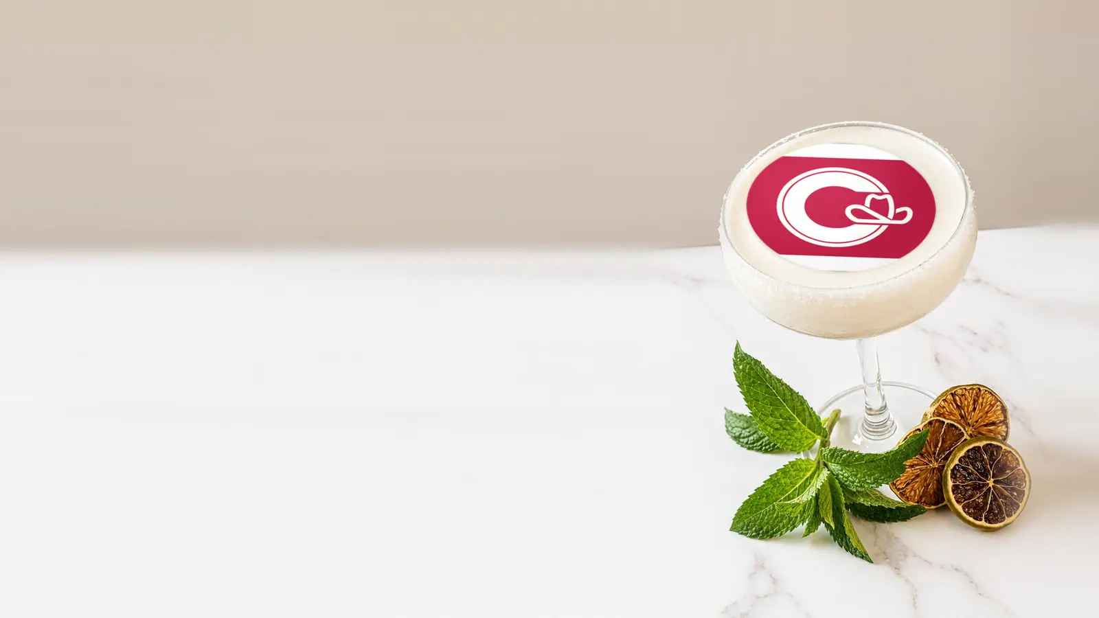 Coupe cocktail topped with a round edible frosting sheet topper printed with the Calgary city flag