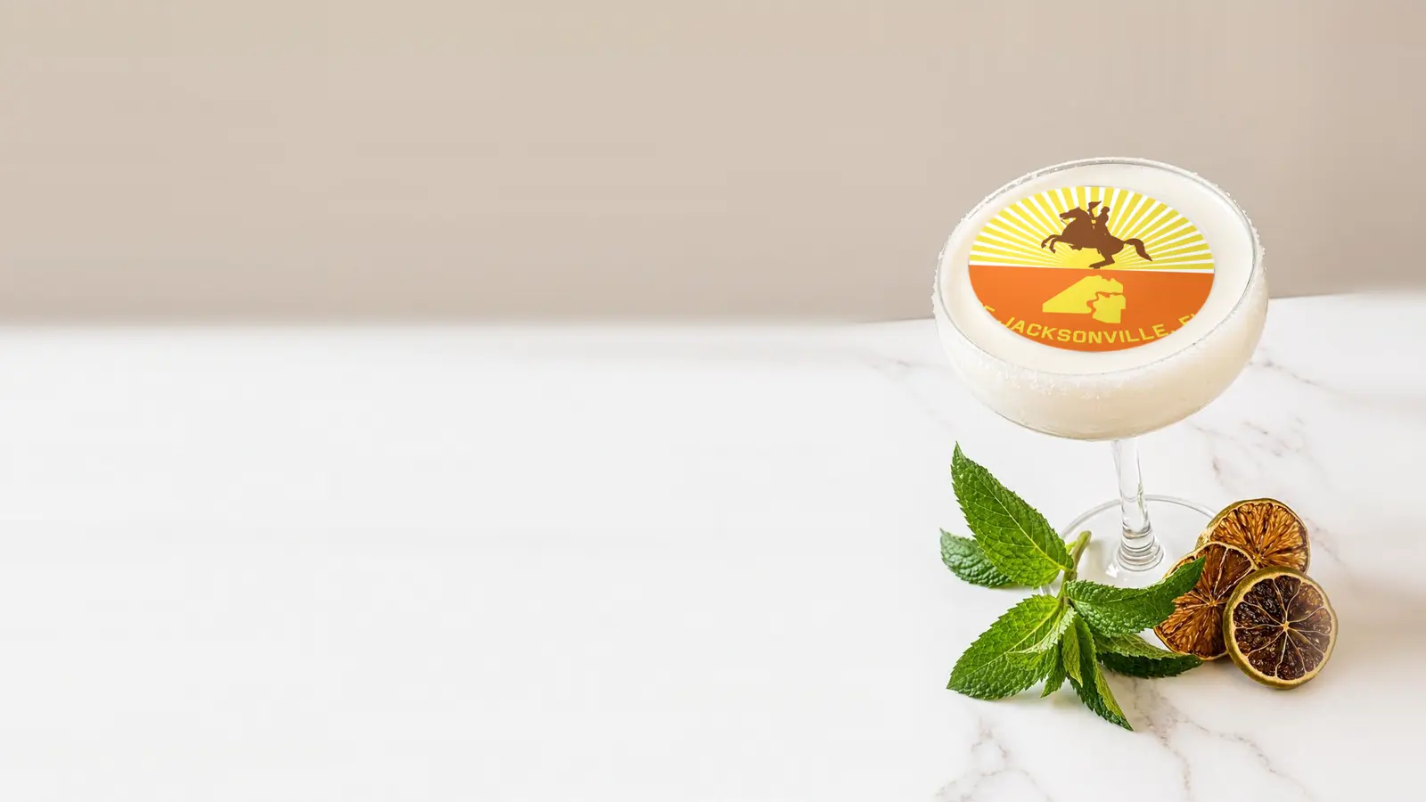 Coupe cocktail topped with a round edible frosting sheet topper printed with the Jacksonville city flag