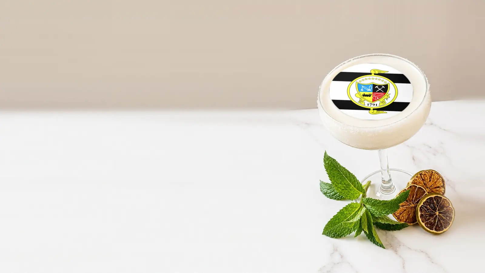 Coupe cocktail topped with a round edible frosting sheet topper printed with the Knoxville city flag