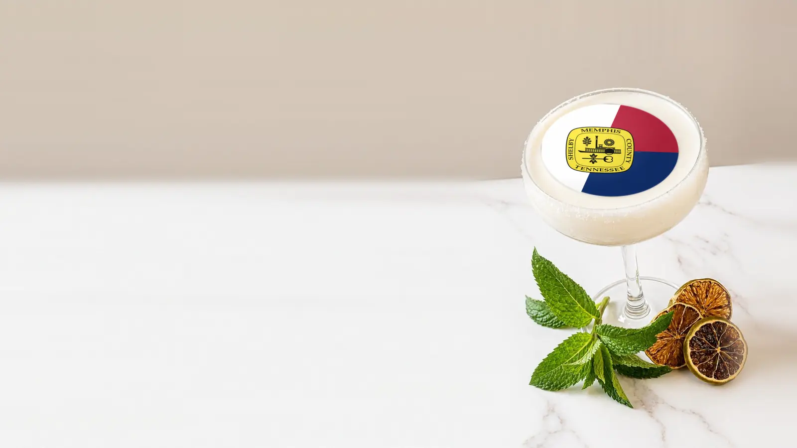 Coupe cocktail topped with a round edible frosting sheet topper printed with the Memphis city flag