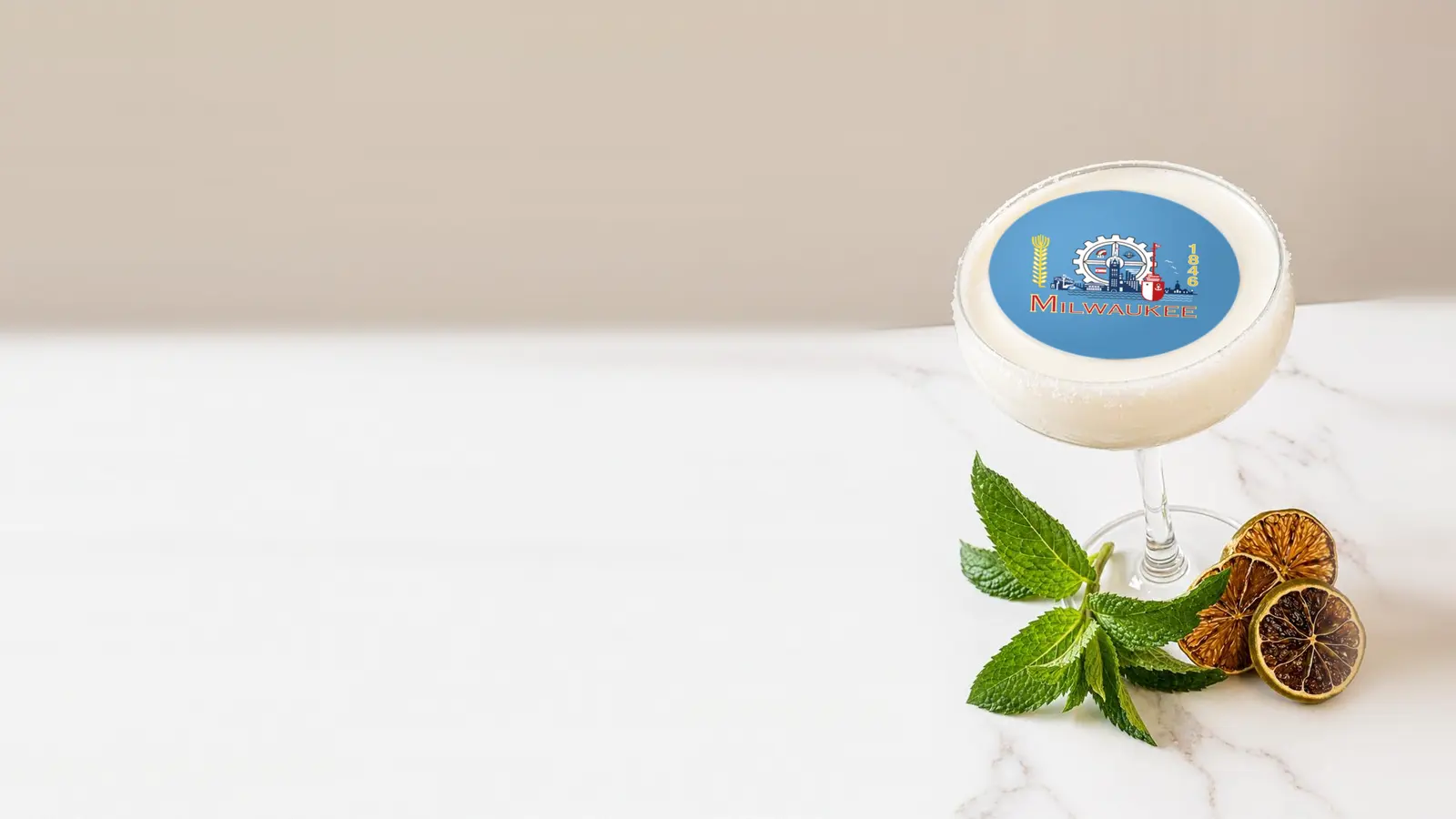 Coupe cocktail topped with a round edible frosting sheet topper printed with the Milwaukee city flag