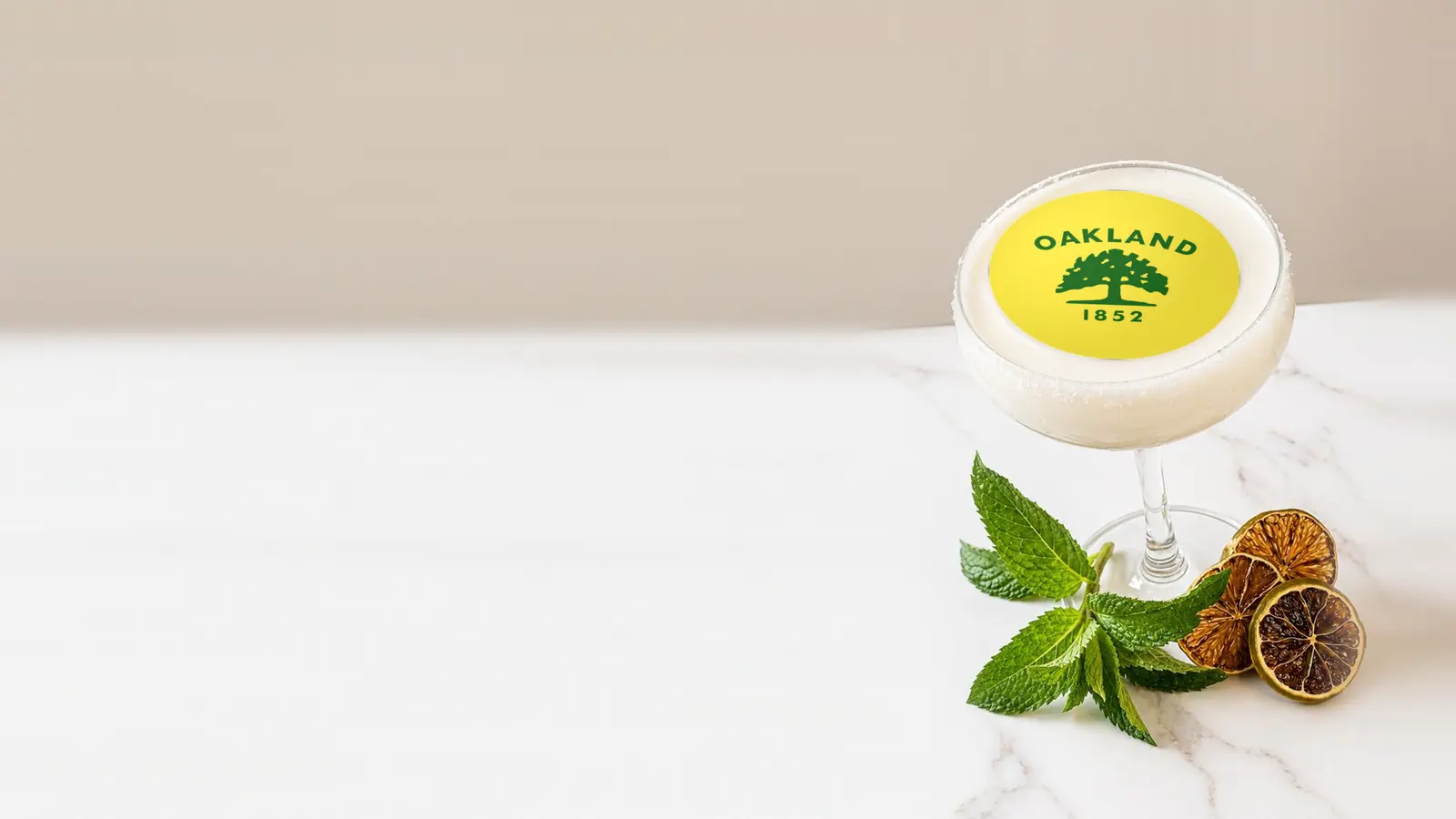 Coupe cocktail topped with a round edible frosting sheet topper printed with the Oakland city flag