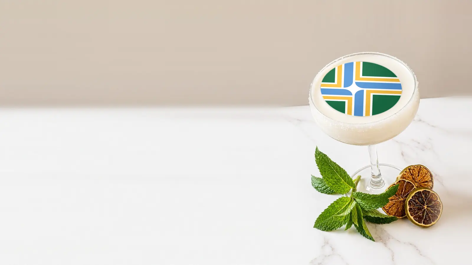 Coupe cocktail topped with a round edible frosting sheet topper printed with the Portland city flag