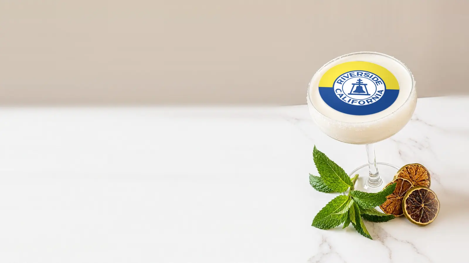 Coupe cocktail topped with a round edible frosting sheet topper printed with the Riverside city flag