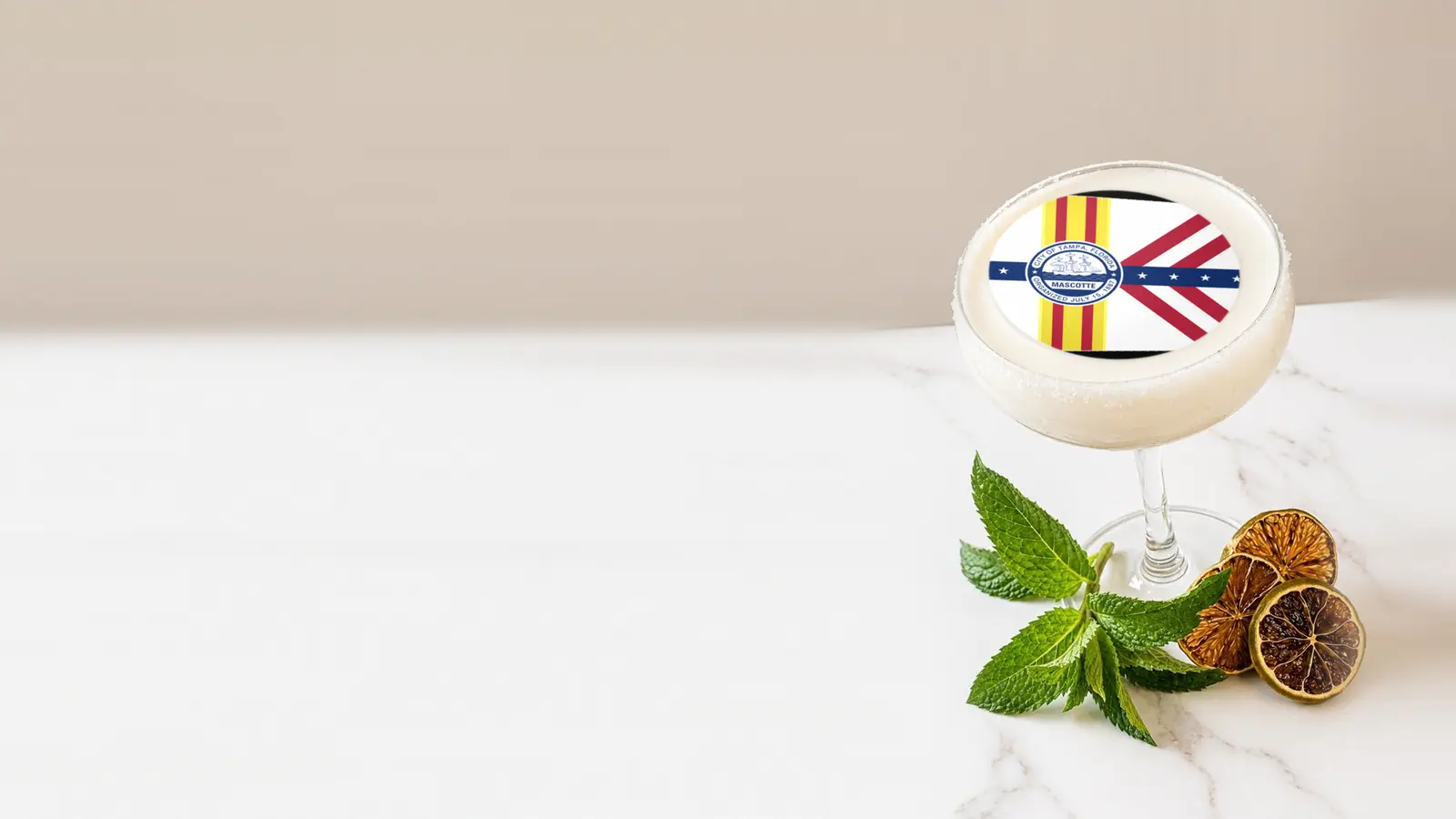Coupe cocktail topped with a round edible frosting sheet topper printed with the Tampa city flag
