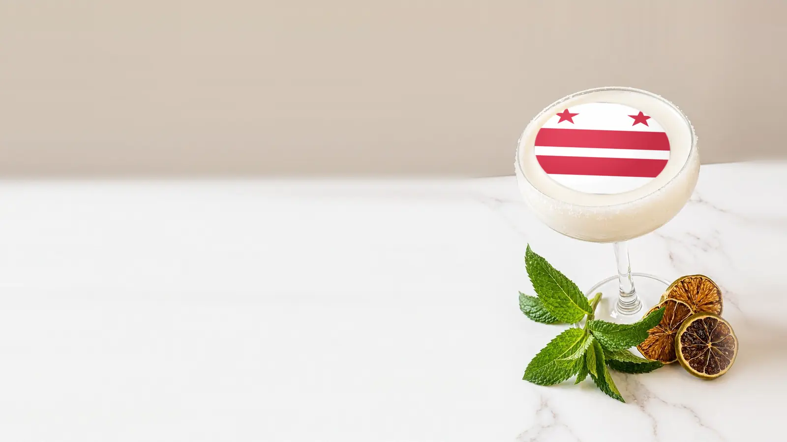 Coupe cocktail topped with a round edible frosting sheet topper printed with the District of Columbia flag