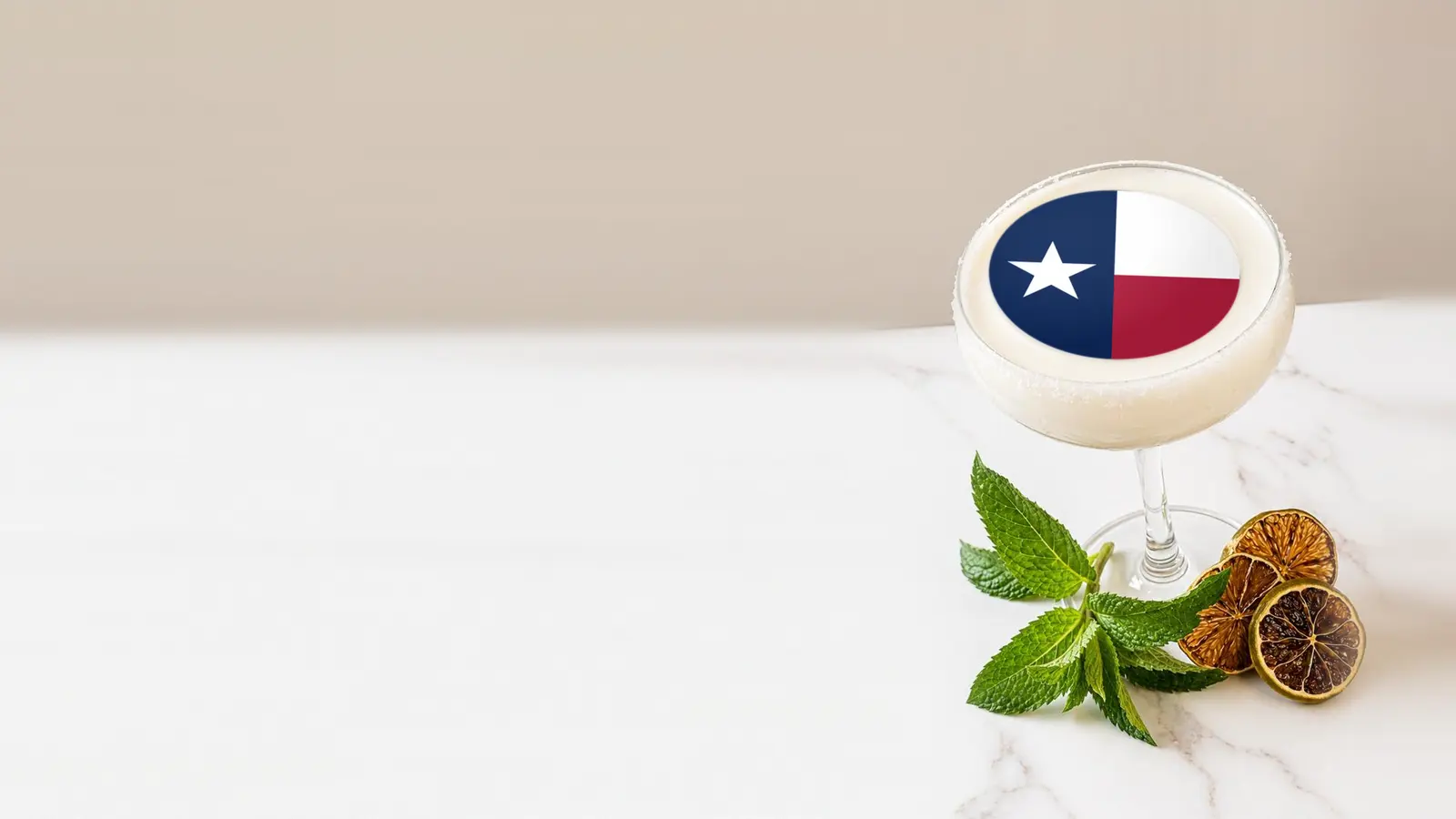 Coupe cocktail topped with a round edible frosting sheet topper printed with the Texas state flag