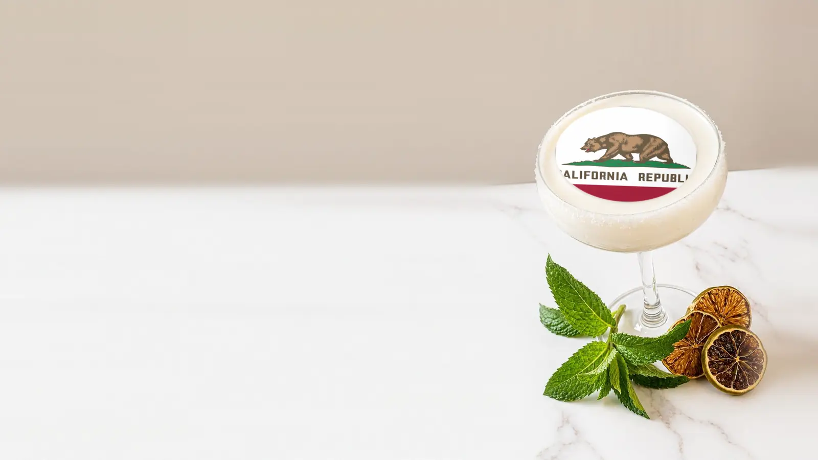 Coupe cocktail topped with a round edible frosting sheet topper printed with the California state flag