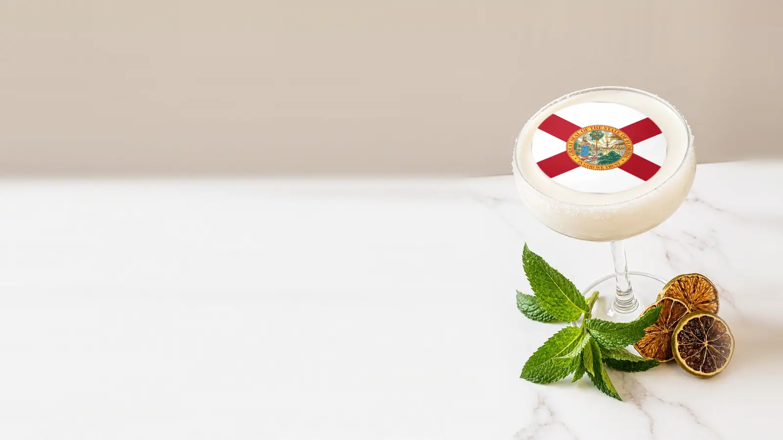 Coupe cocktail topped with a round edible frosting sheet topper printed with the Florida state flag