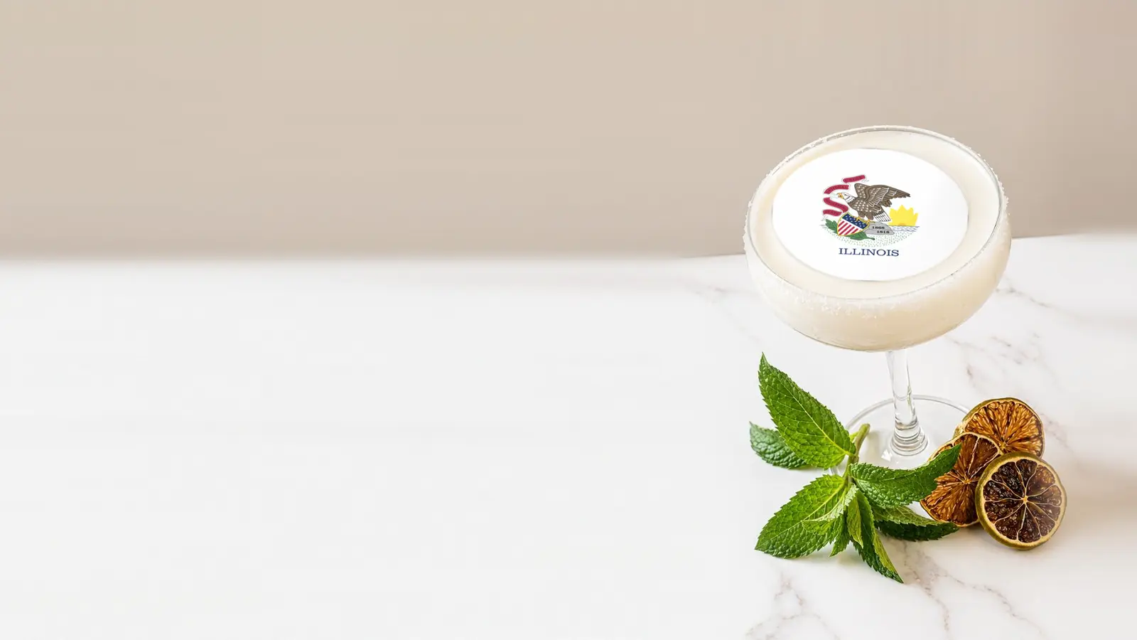 Coupe cocktail topped with a round edible frosting sheet topper printed with the Illinois state flag