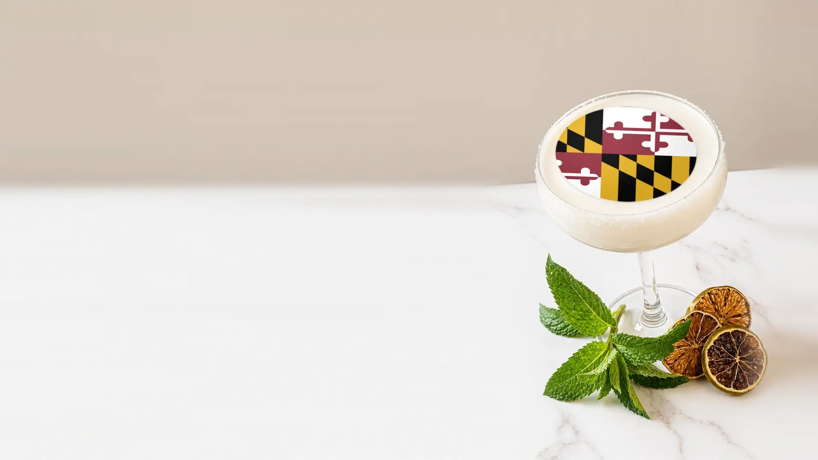 Coupe cocktail topped with a round edible frosting sheet topper printed with the Maryland state flag