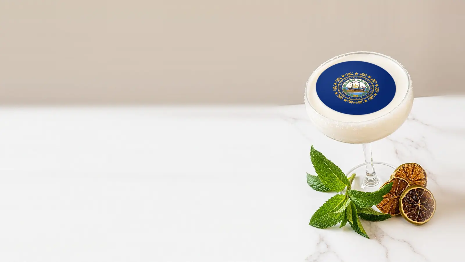 Coupe cocktail topped with a round edible frosting sheet topper printed with the New Hampshire state flag