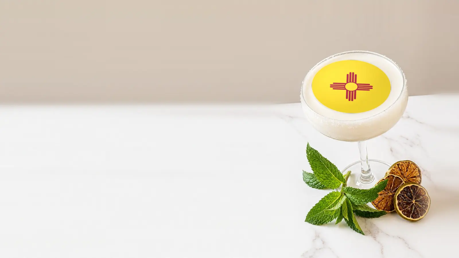 Coupe cocktail topped with a round edible frosting sheet topper printed with the New Mexico state flag