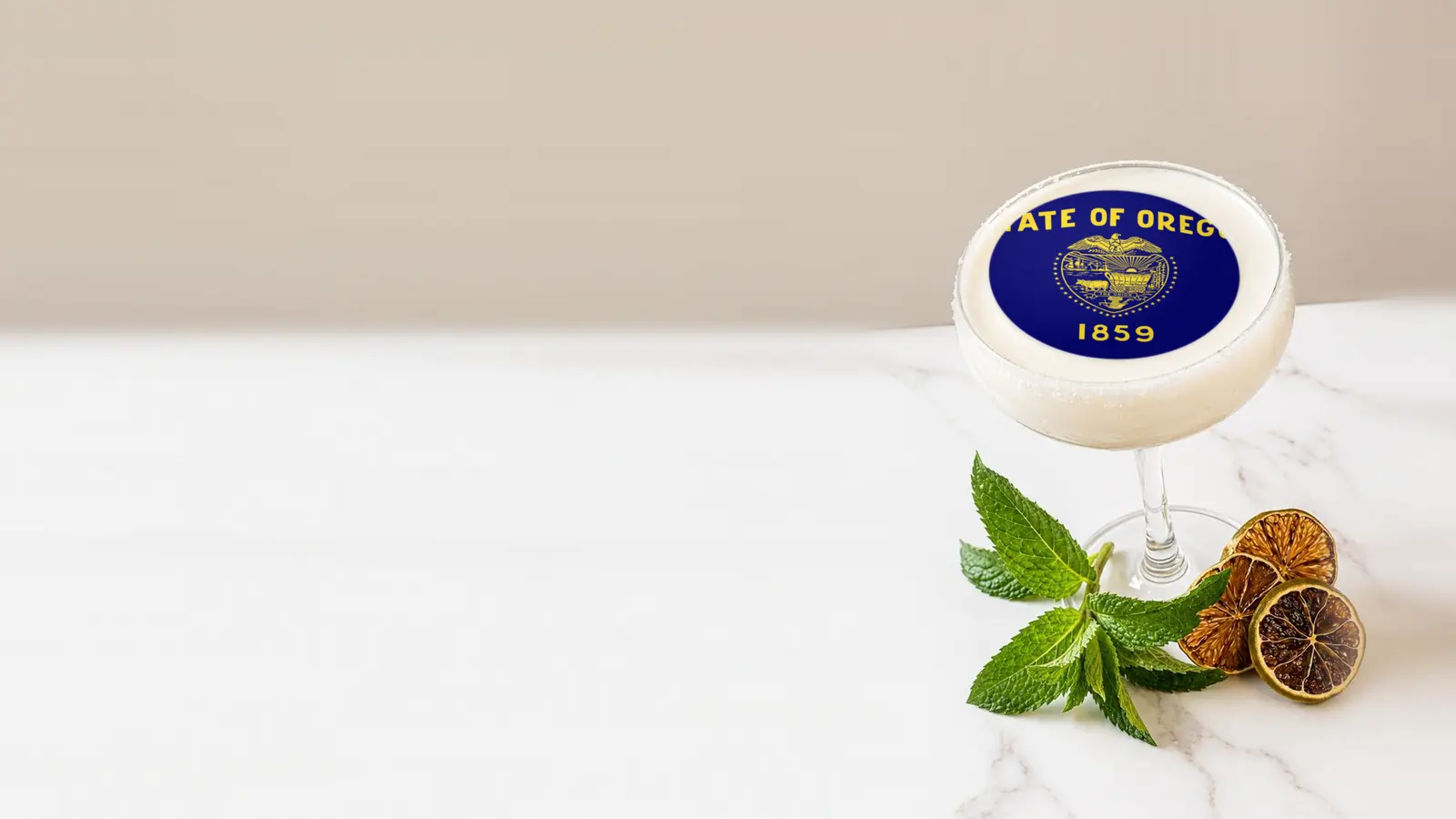 Coupe cocktail topped with a round edible frosting sheet topper printed with the Oregon state flag