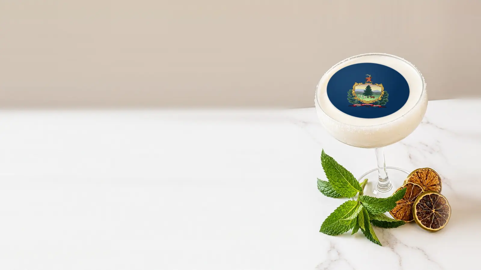 Coupe cocktail topped with a round edible frosting sheet topper printed with the Vermont state flag