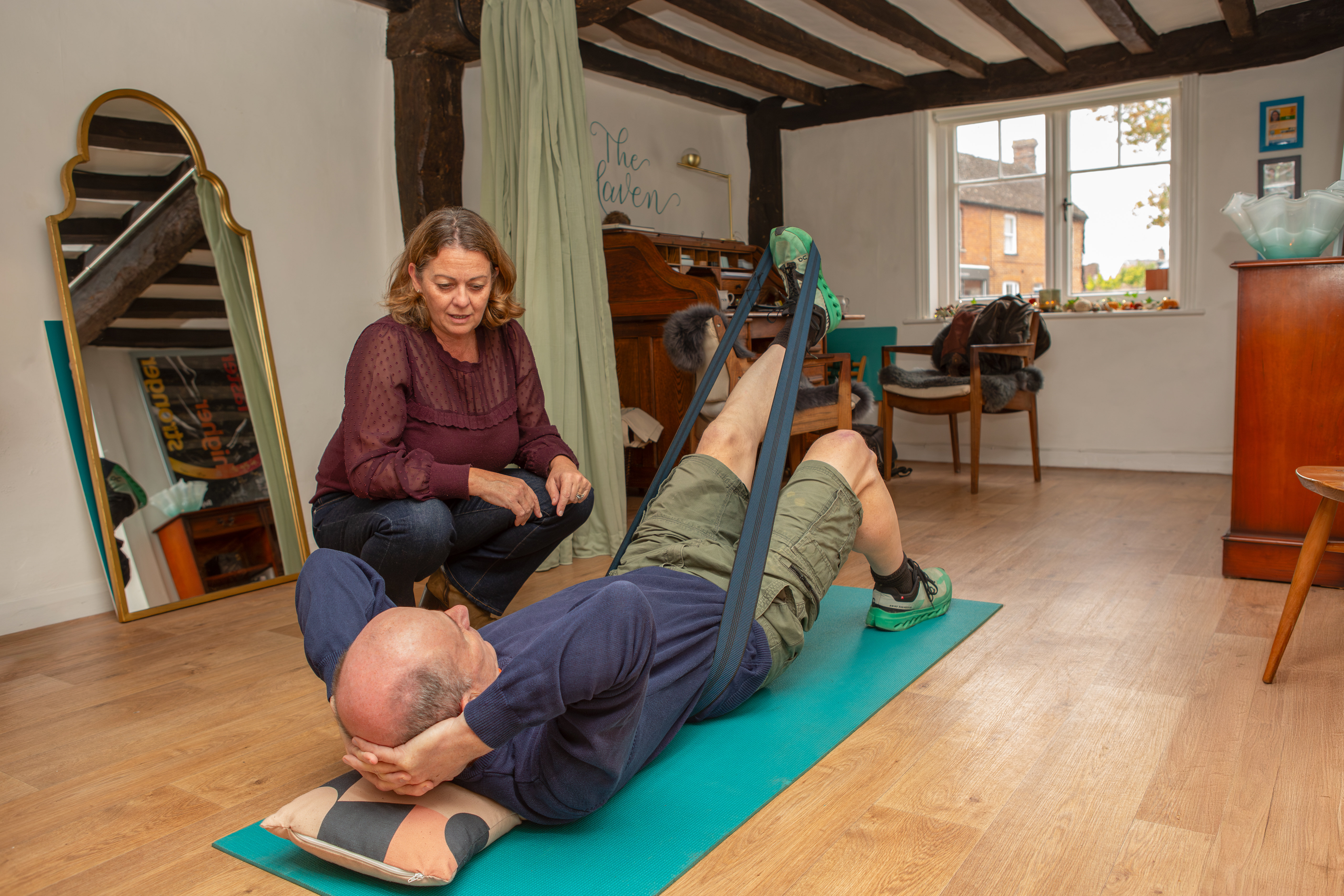 Physiotherapist Lisa Kerry providing hands-on foot and ankle treatment to a client lying face down on a treatment table in a calm, home-style clinic setting