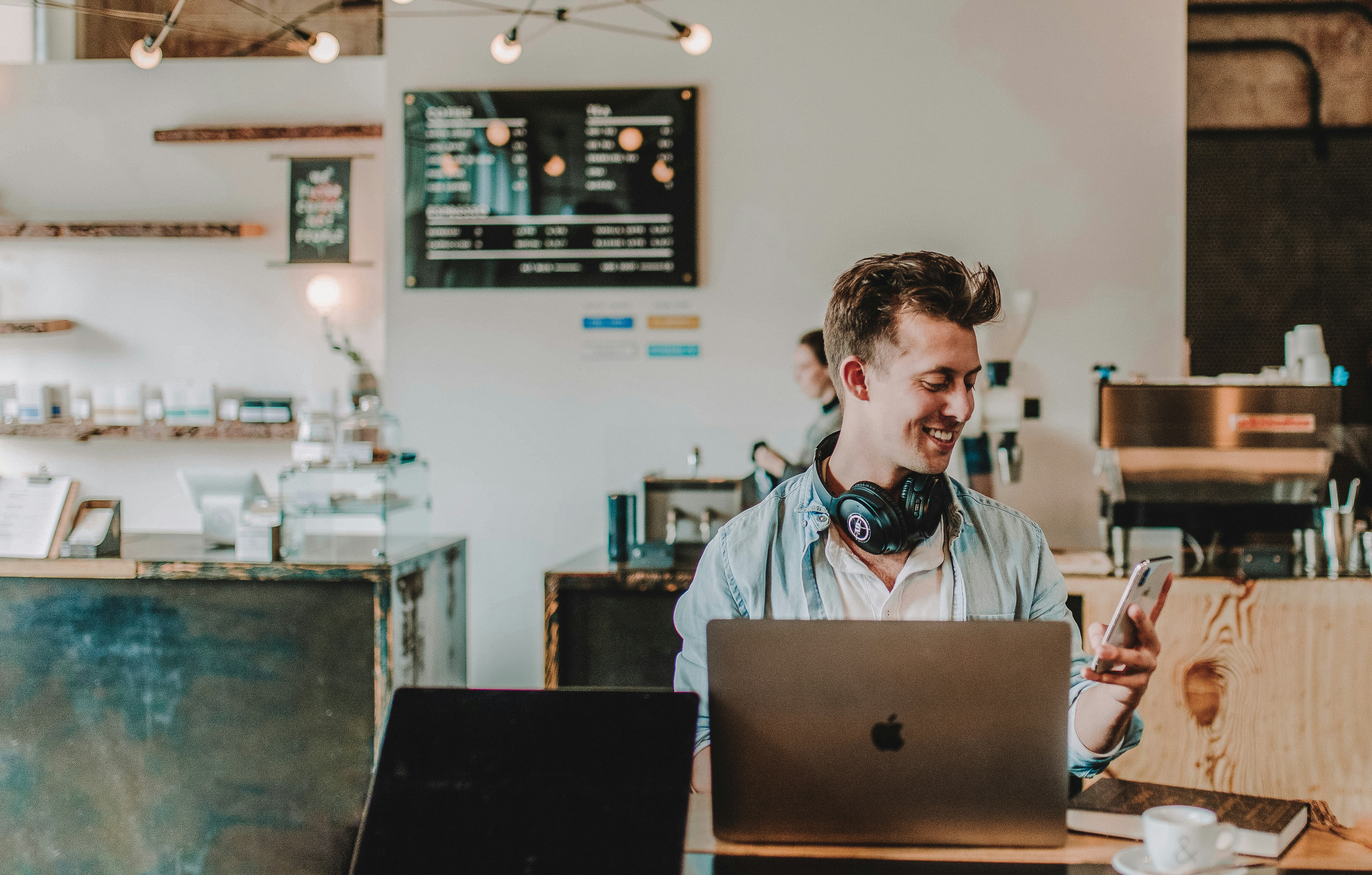 A person with a laptop sitting in a coffee shop A person with a laptop sitting in a coffee shop