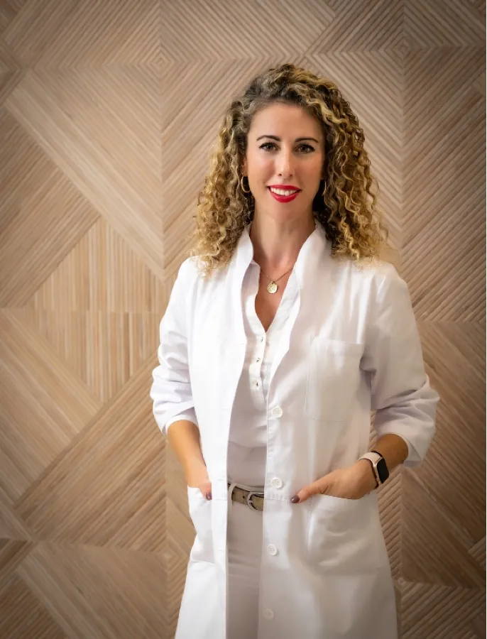Retrato de la Dra. Cristina López Obregón con bata blanca en la clínica.