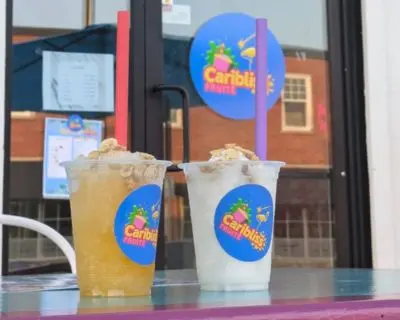 Deux jus, un jaune et un blanc coco, devant la vitrine de Caribliss Fruité