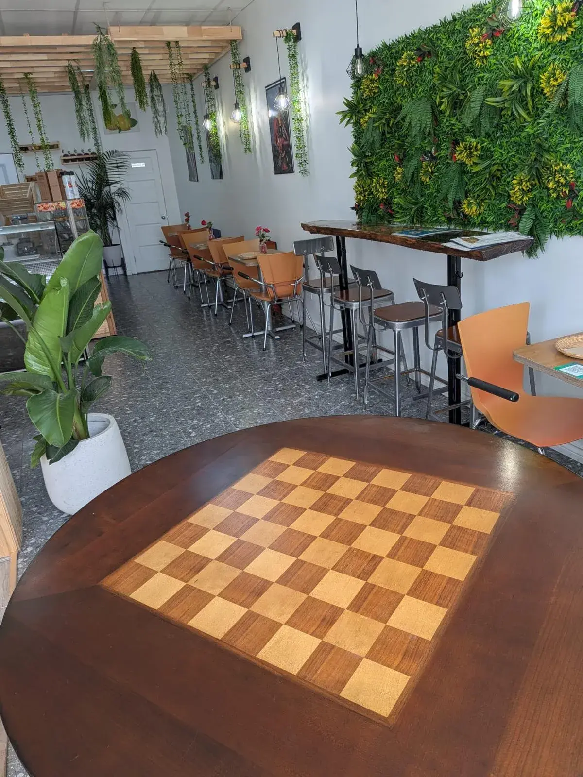 Mur végétal et table de jeu en bois dans le salon de Caribliss Fruité