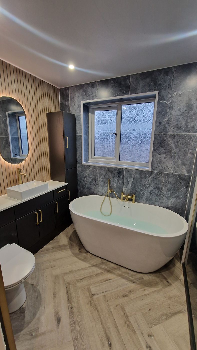 Freestanding bath with brushed gold taps and slat wall panelling