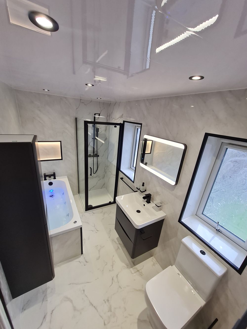 Monochrome bathroom with spa bath and separate shower