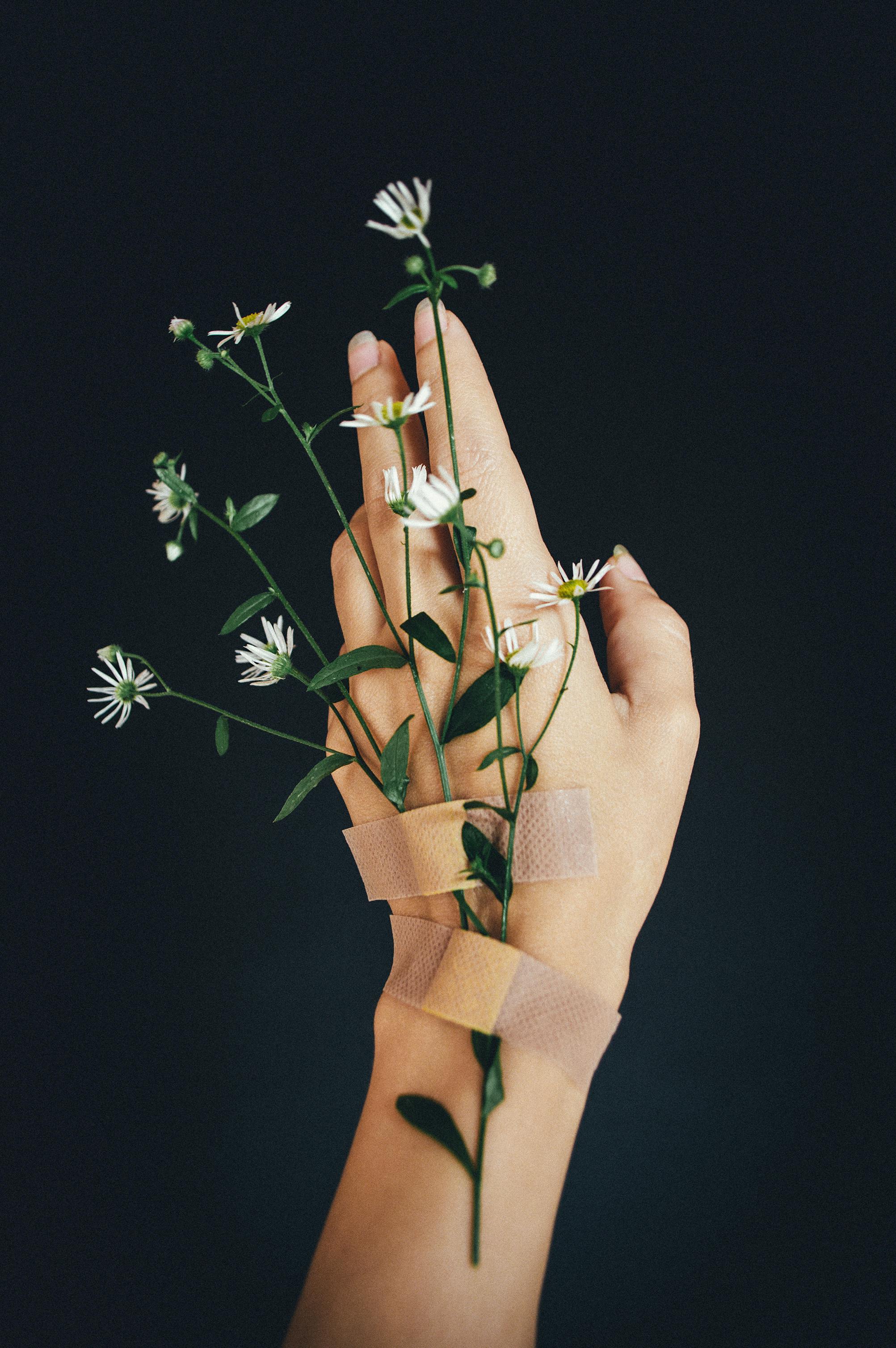 A hand with bandages and flowers