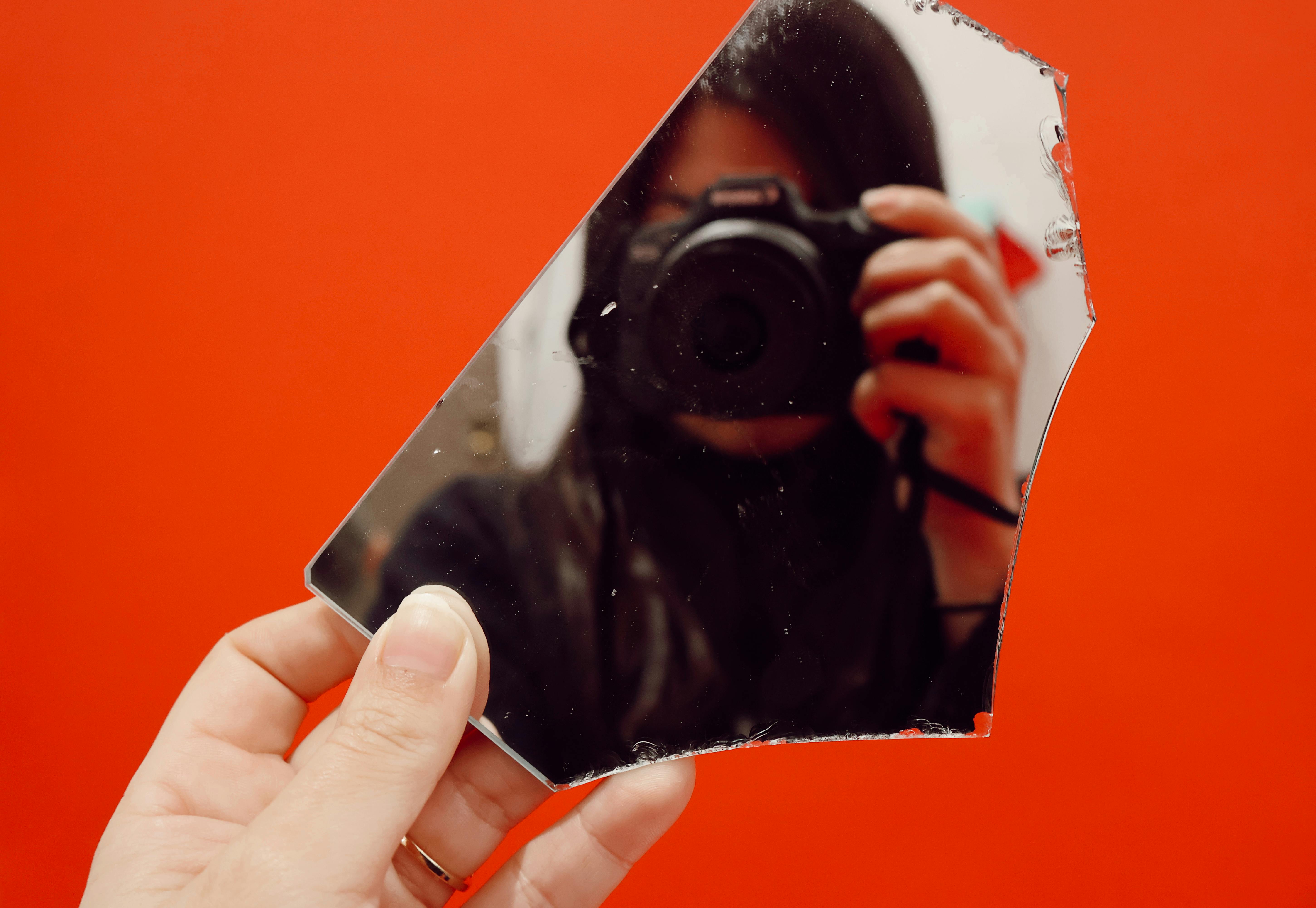Someone taking a photo of themself through a mirror shard