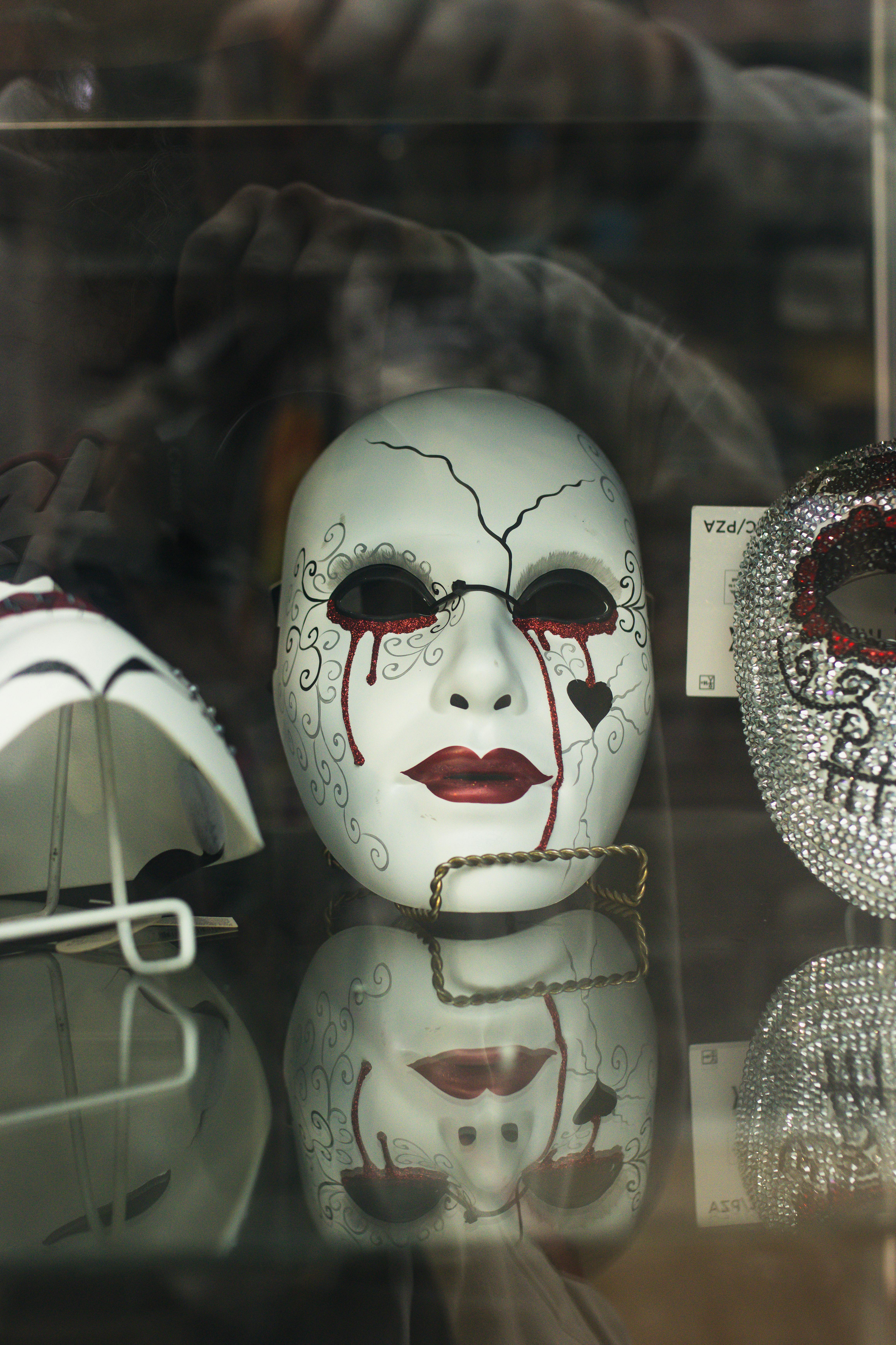 A mask crying tears with a broken heart