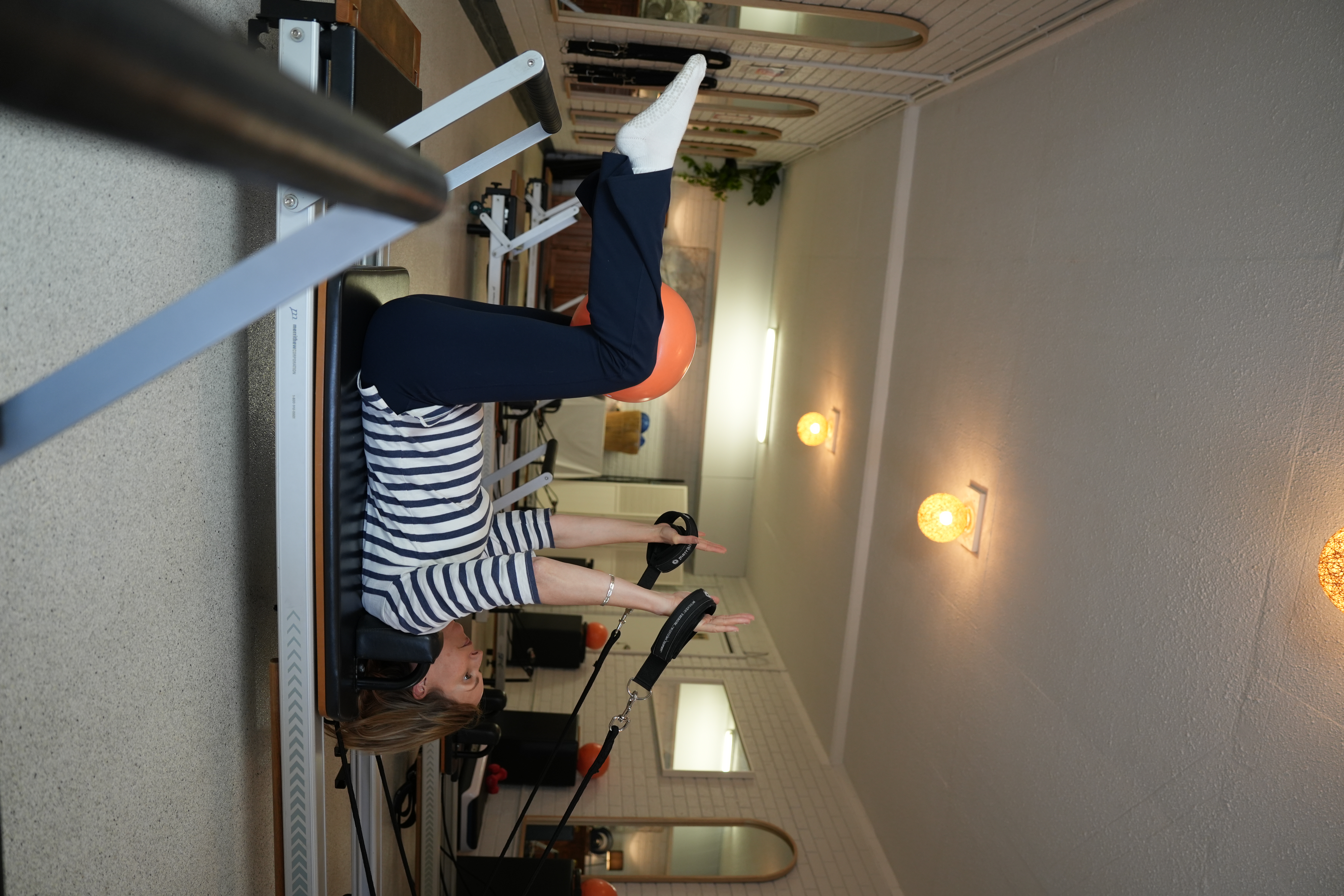 Client in a standing Reformer Pilates pose at Pilates at Sarah's studio in Point Clare, demonstrating balance and control on the reformer