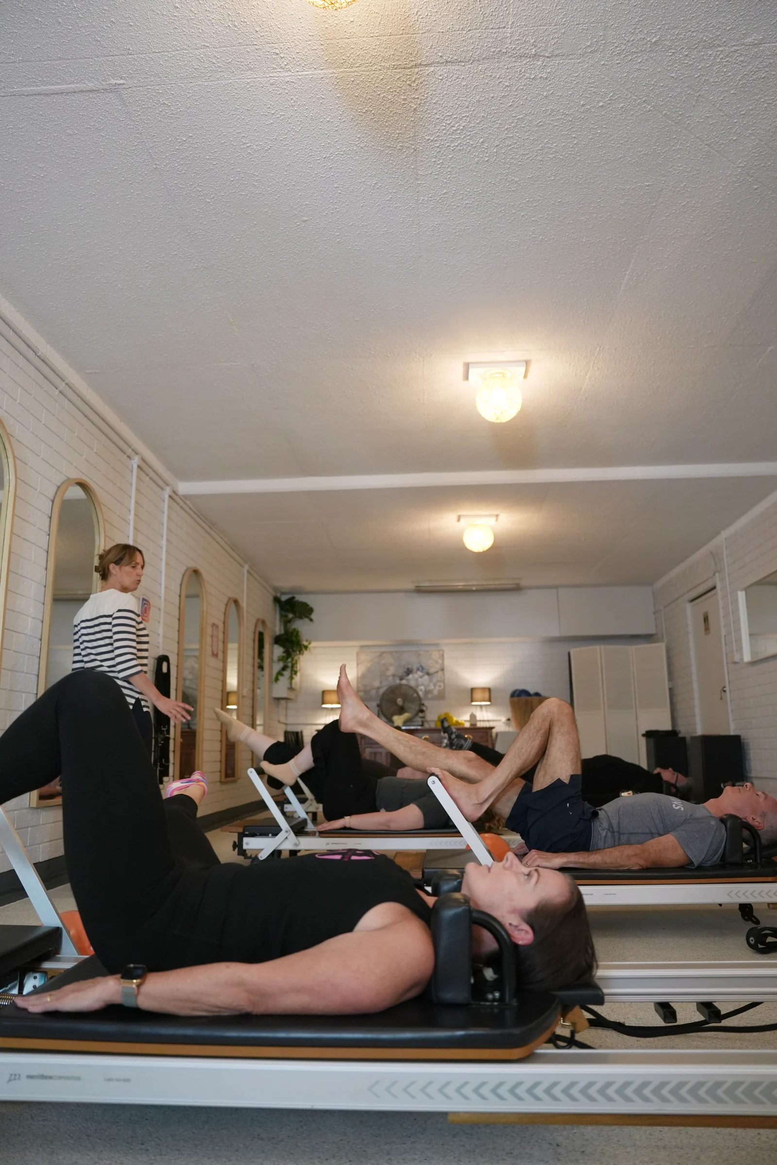 Client performing a seated Reformer Pilates exercise at Pilates at Sarah's studio in Point Clare, focusing on controlled movement and alignment