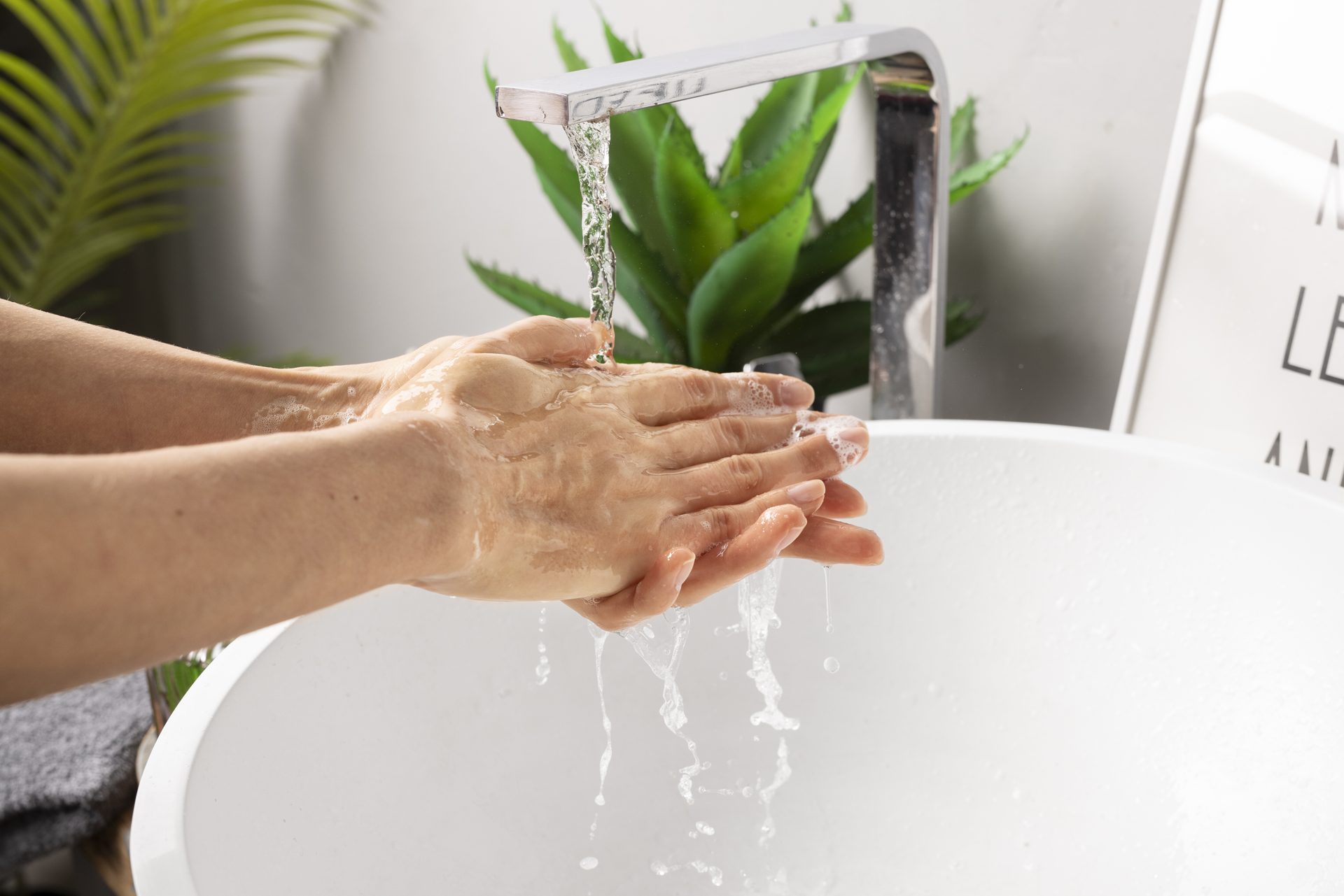 Mains sous un robinet d'eau traitée