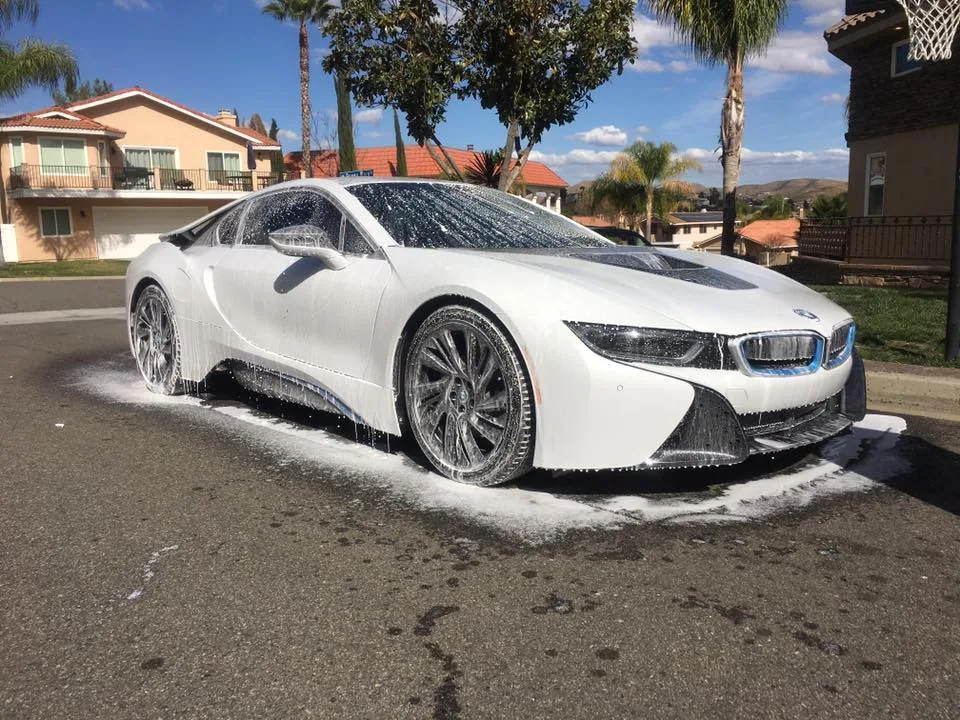 BMW i8 receiving thick pH-neutral snow foam pre-wash bath from mobile detailing rig