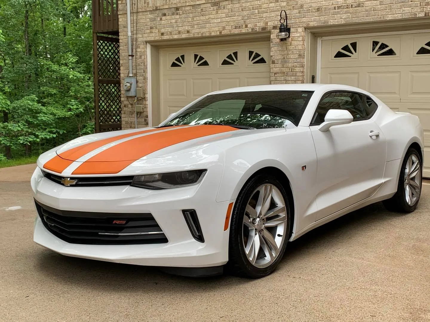 White Chevrolet Camaro RS with orange racing stripes detailed to showroom condition
