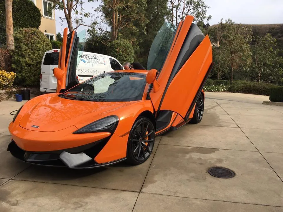 Pacific Coast Detailing mobile service van detailing orange McLaren supercar on-site