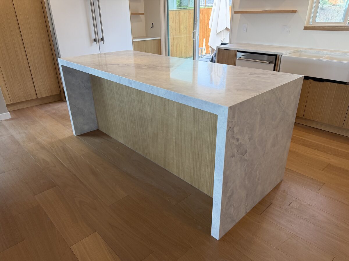 Mitered waterfall edge quartzite kitchen island with light veining