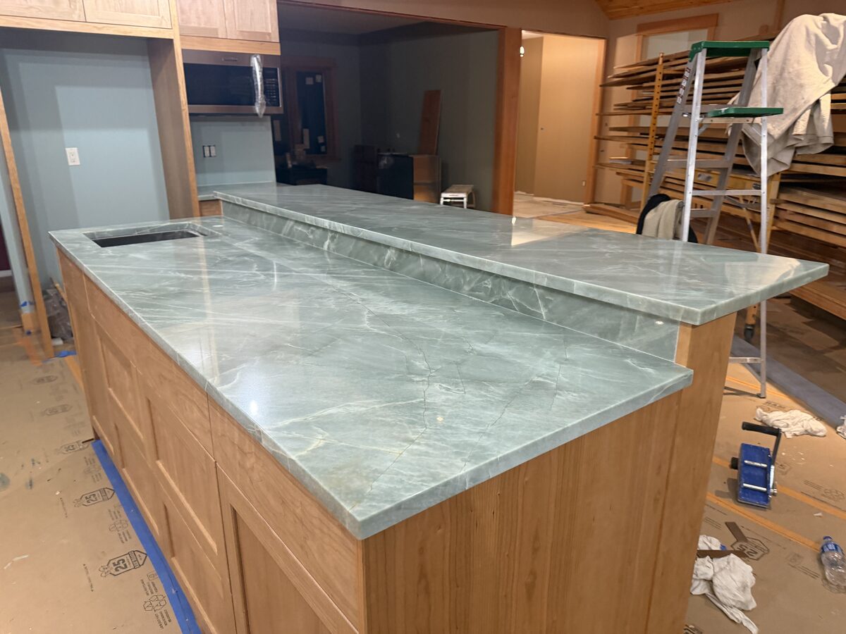 Green quartzite kitchen island with raised bar