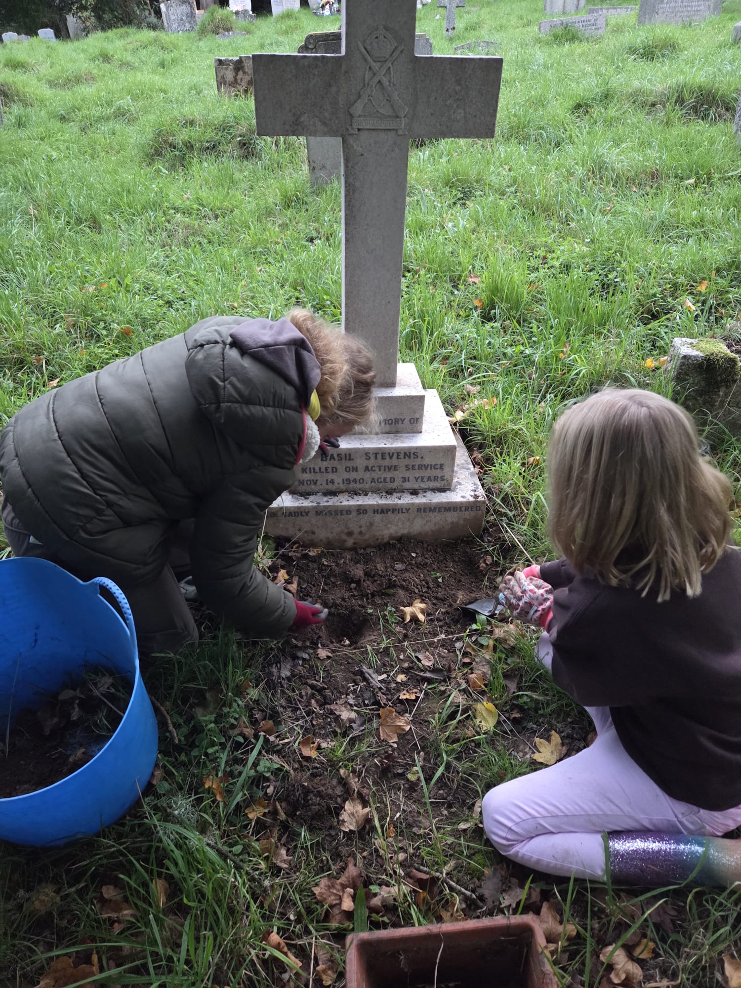 Chiddingfold Brownies planting crocuses around the war graves purchased with funds raised at the Chiddingfold Village Fete