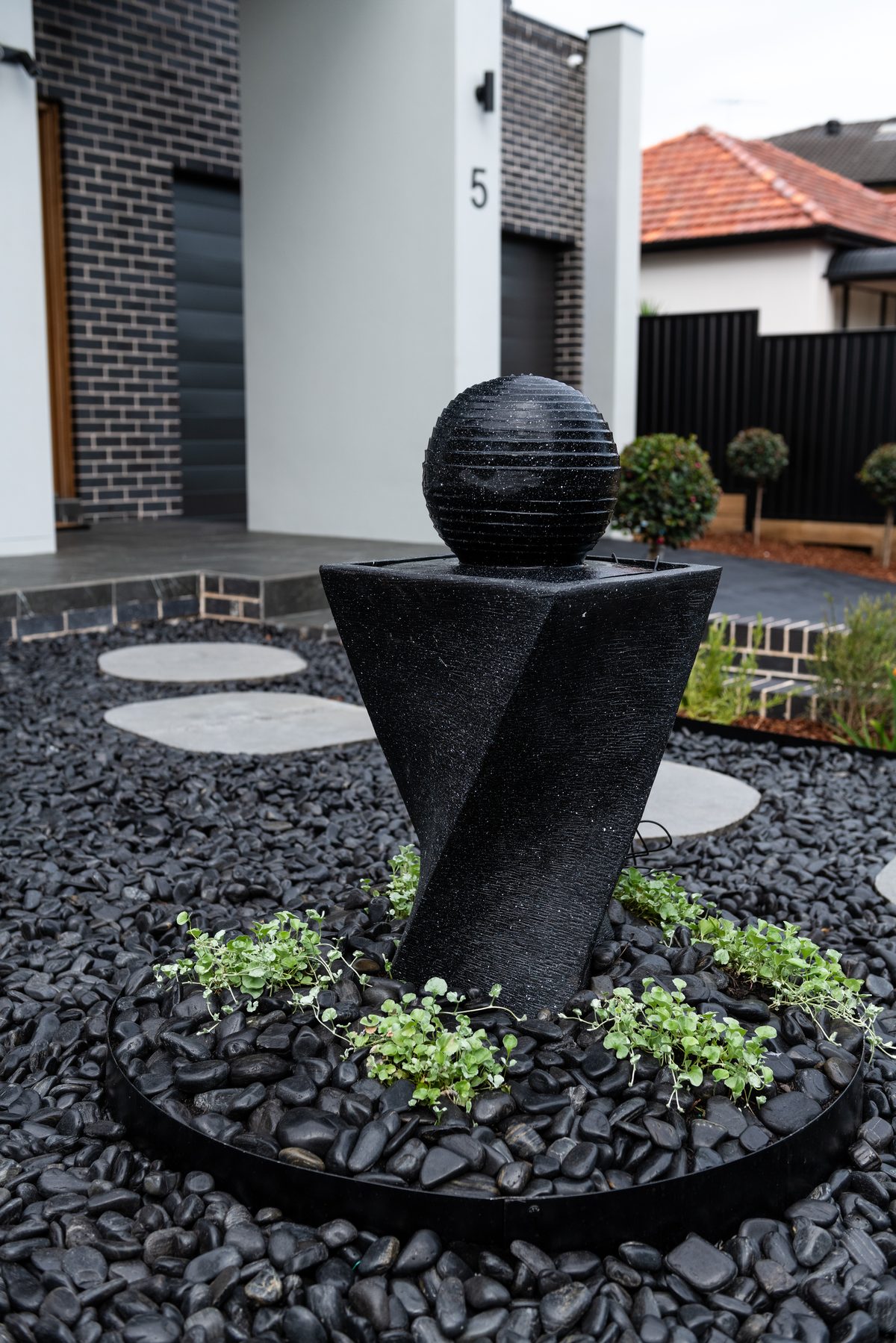 Chifley front yard, black pebbles and water feature
