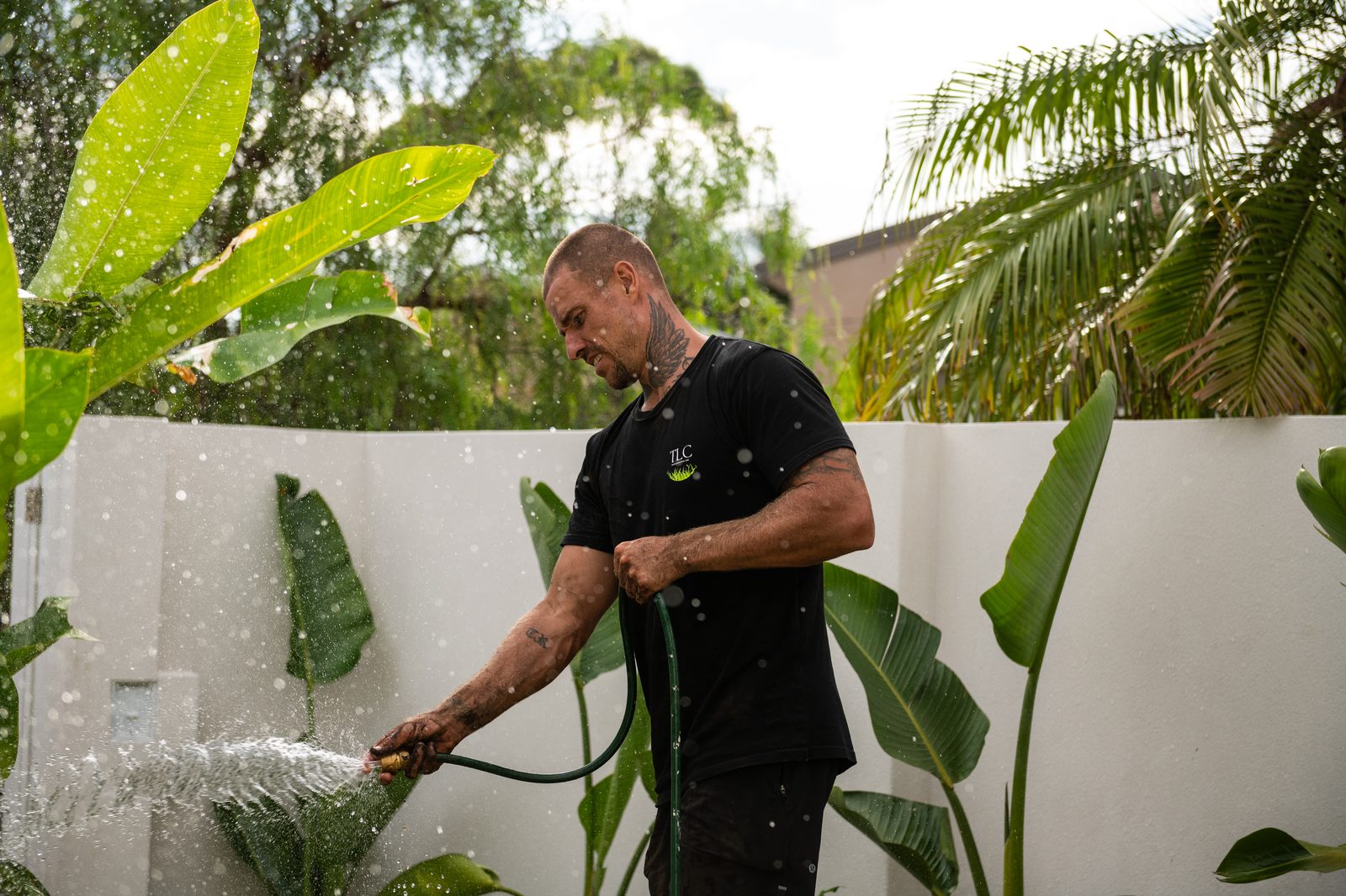 Troy working in a garden wearing the TLC shirt