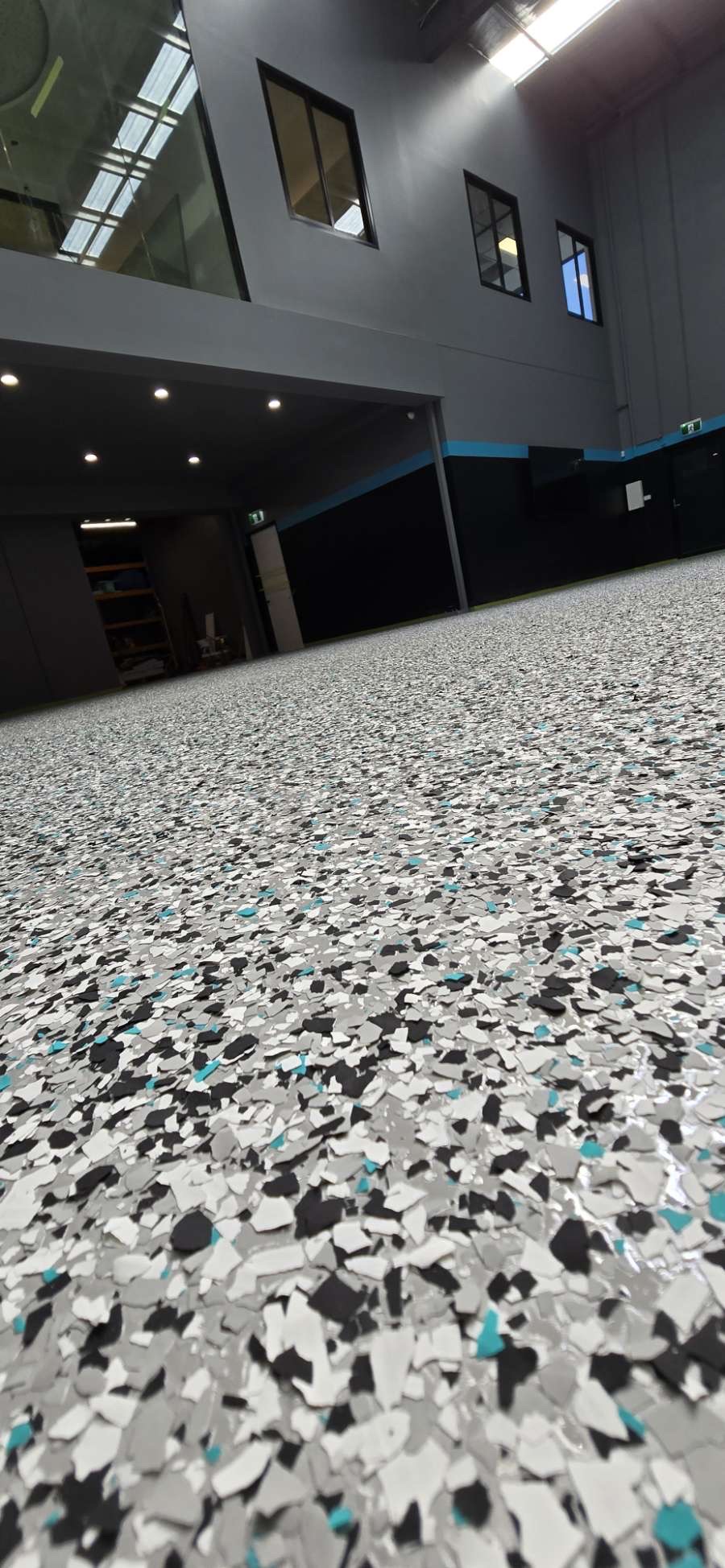 Factory concrete slab before epoxy resurfacing, showing surface wear and staining